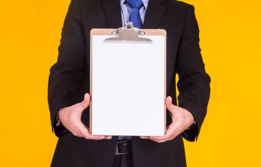 Sarı arka planda boş reklam panosu olan iş adamı.