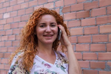 Sokakta cep telefonuyla konuşan bir kadın.