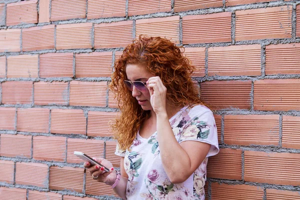 Woman Using Mobile Phone Brick Wall Background — Stock Photo, Image