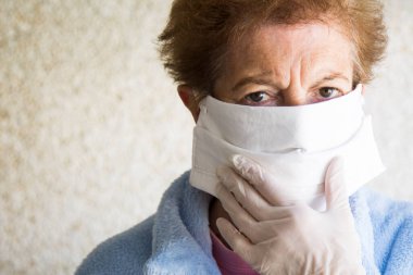 Tek kullanımlık tıbbi maskeli yaşlı bir kadının portresi. Coronavirüs salgını sırasında kamusal alanlarda güvenlik.