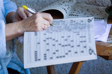 senior woman doing crossword puzzles or hobbies sitting clipart