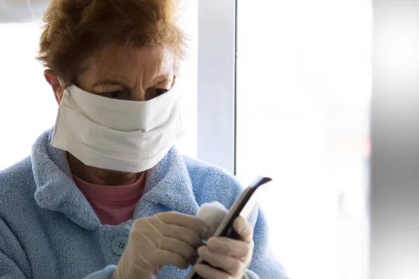 Starší Žena Lékařskou Maskou Dezinfikující Mobilní Telefon Bavlnou Alkoholem Aby — Stock fotografie