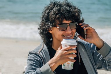 Deniz kenarında konuşan adam.