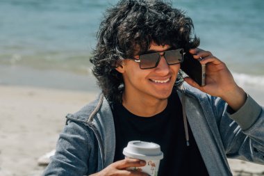 Deniz kenarında konuşan adam.