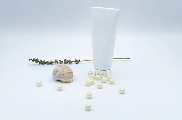 Lavanta deniz inci ve beyaz bir arka plan üzerinde izole bir kabuk ile kozmetik ya da sağlık tüp