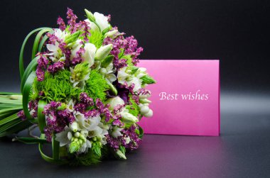 Beautiful bouquet with roses, carnations and ornithogalum or star of bethlehem flowers with a pink greeting card signed with best wishes example text isolated on a black background clipart