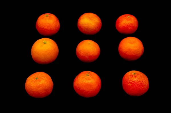 Simetrik ve güçlü bir siyah arka plan üzerine zıt taze portakal mandalina kurdu