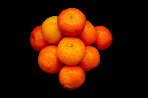 Simetrik ve güçlü bir siyah arka plan üzerine zıt taze portakal mandalina kurdu
