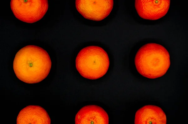 Simetrik ve güçlü bir siyah arka plan üzerine zıt taze portakal mandalina kurdu