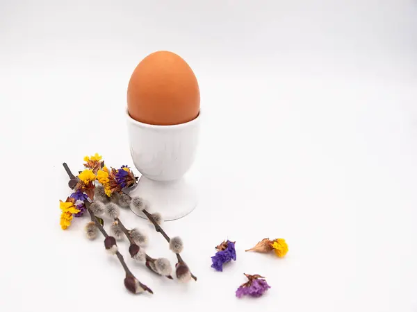 Paskalya kahvaltı kavramı bir haşlanmış yumurta, söğüt dalları ve beyaz bir arka plan üzerinde izole birkaç kurutulmuş limonium çiçek