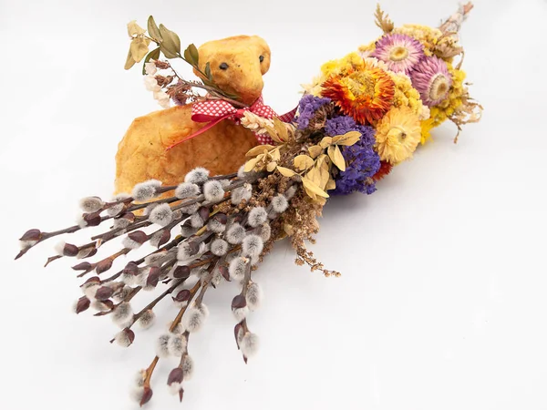 Traditional religious Easter willow branches decorated with dried flowers and a backed Easter bread in a form of a lamb isolated on a white background