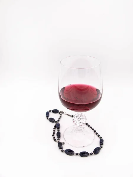 Beyaz bir arka plan üzerinde izole bir siyah inci kolye ile kırmızı şarap