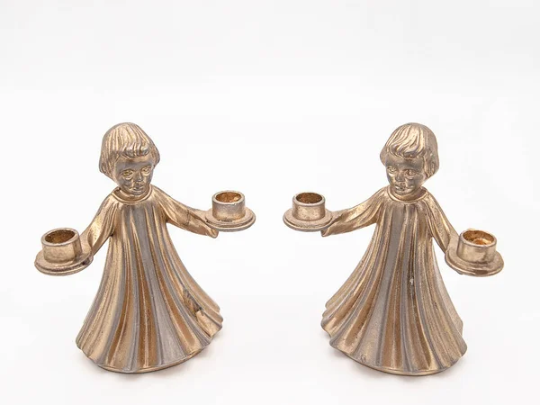 Beyaz bir arka plan üzerinde izole iki mum tutan bir çocuk şeklinde bronz mumluk çifti