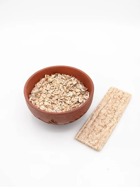 Seramik tabak bir diyet gevrek ekmek veya bisküvi olarak sağlıklı beslenme beyaz bir arka plan üzerinde izole, kavramı ile kuru yulaf ezmesi