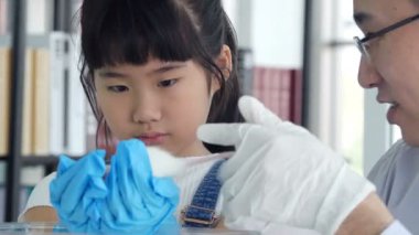 Laboratuvardaki küçük Asyalı kız test yapıyor. 