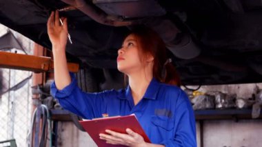 Otomobil tamircisinde çalışan bir kadının görüntüleri.
