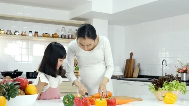 白いキッチンで料理する娘の母親の映像 — ストック動画