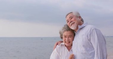 Asırlık bir çiftin sahilde yürürken birbirlerine eşlik etmelerinin görüntüleri.