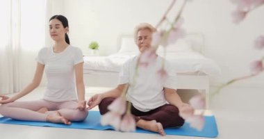 Birlikte yoga yapan Asyalı kadınların görüntüleri.