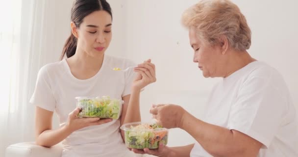 Joven Con Madre Comiendo Ensalada Mientras Está Sentada Sofá Blanco — Vídeos de Stock