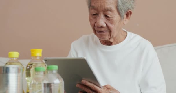 Senior Vrouw Met Behulp Van Tablet Prijs Van Het Product — Stockvideo