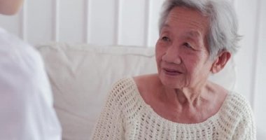 Bayan doktor, son sınıf öğrencisini ziyaret ediyor. Kadın doktor, evdeki sağlık muayenesinde hastaya yardım ediyor. Yaşlı büyükanne, bakıcı destek veriyor. Sağlık ve Tıp Konsepti