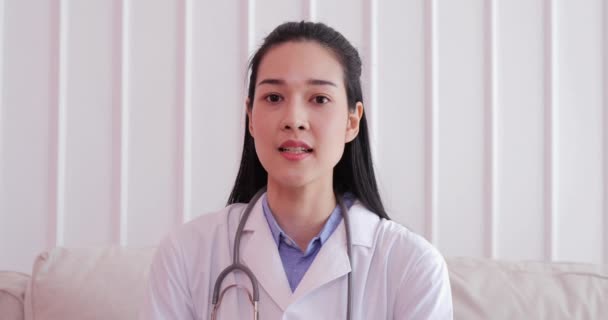 美丽的女医生在视频聊天中与病人交谈 亚洲女医生在工作场所利用在线会议 同时看网络摄像头 — 图库视频影像