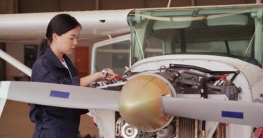 Mavi üniformalı kadın uçak üretiminde mühendis olarak çalışıyor.