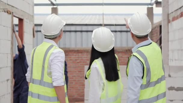 戴着硬礼帽的男女在建筑工地讨论工作过程 — 图库视频影像
