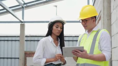 Kadın ve erkek inşaat alanında çalışma sürecini tartışıyorlar.