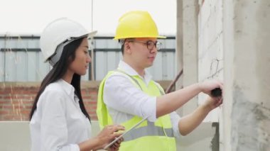 Kadın ve erkek inşaat alanında çalışma sürecini tartışıyorlar.