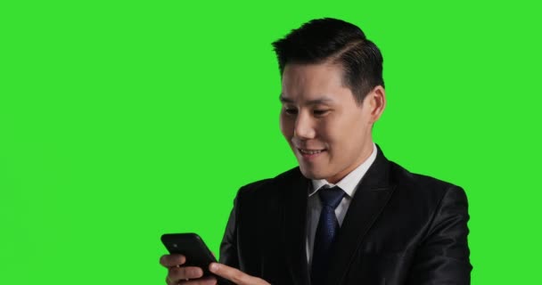 Азиатский Человек Костюме Помощью Телефона Зеленом Фоне — стоковое видео