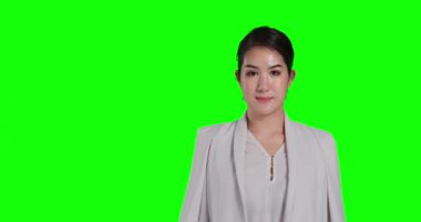 Asyalı kadın yeşil arka planda poz veriyor.