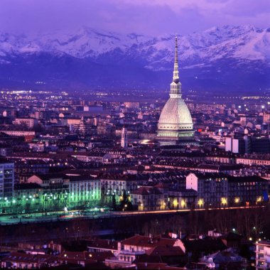 Torino, Piedmont, İtalya. Kuzey İtalya 'nın günbatımında bir şehir manzarası. Arka planda sembol oluşturan Köstebek Antonelliana ve Karlı Alpler var..
