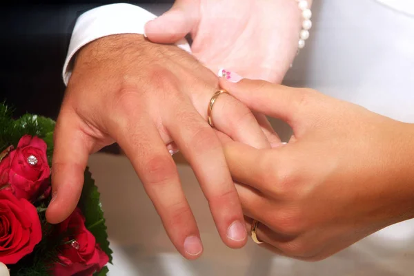 Bride's hand puts the wedding ring in the groom's finger — Stock Photo, Image