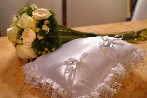 Close up van trouwringen van de pasgetrouwden met het boeket van de bloemen op de achtergrond — Stockfoto