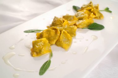 İtalyan yemek tarifleri, taze makarna Agnolotti del plin tereyağı ve adaçayı sosu ile doldurulmuş..