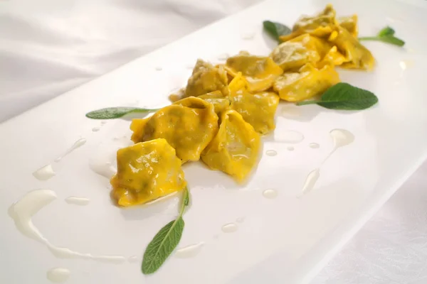 Italienische Küche Rezepte, frische gefüllte Pasta agnolotti del plin mit Butter und Salbeisoße. — Stockfoto