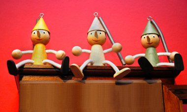 Kırmızı arka planda üç Pinokyo ahşap kuklalar
