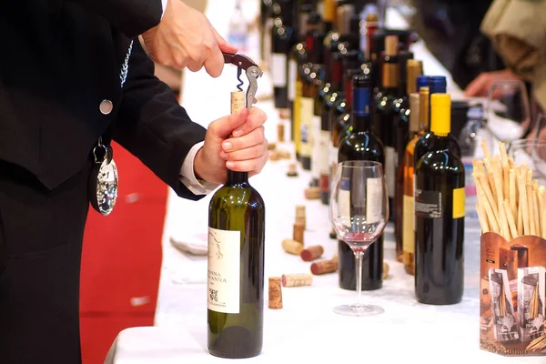 Turin, Piedmont, Italy. -10/26/2009- Fair "Wine show", sommelier uncork a bottle of wine to taste. — Stock Photo, Image