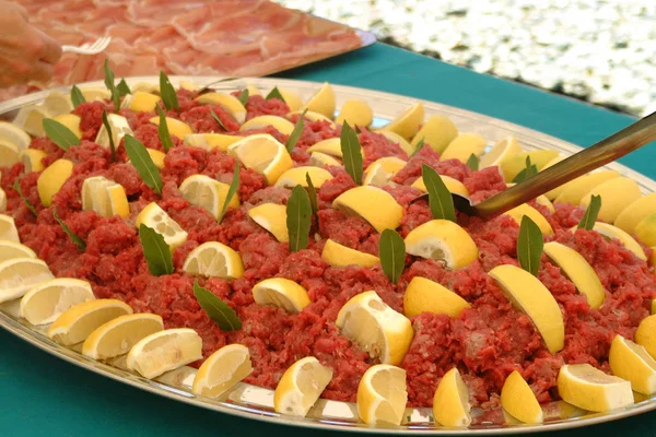 Italiaanse eetrecepten, rauw kalfsvlees, gearomatiseerd met citroensap, zout en olie. — Stockfoto