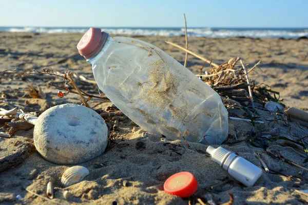 Contaminación plástica de botellas en una playa de arena . — Foto de Stock