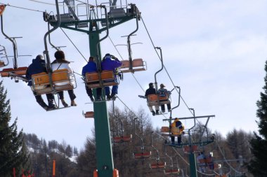 İtalyan Alpleri'nde telesiyej üzerinde Kayakçılar
