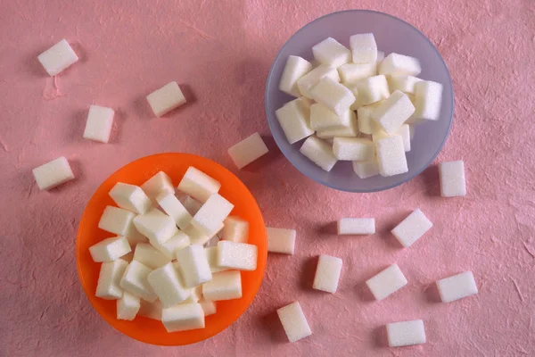 Deux bols colorés remplis de cubes de sucre blanc en angle plat . — Photo