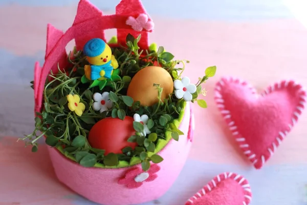 Panier de Pâques en feutre rose avec œufs peints et poulet jaune dans un panier sur fond rose-bleu. Joyeux fond de Pâques pour carte de voeux . — Photo