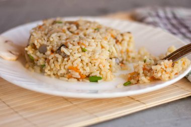 White plate with spicy pilaf with mushrooms