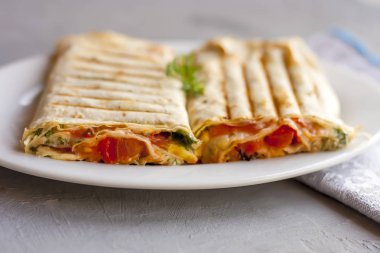 Beyaz plaka üzerinde yeşillik ve domates ile pide ekmek Suluguni