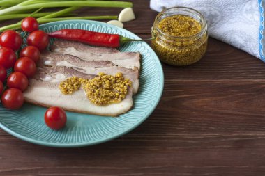 Pişmiş domuz göbek veya pastırma domates ile bir plaka ince dilimleri içine dilimlenmiş, hardal ile döktü.