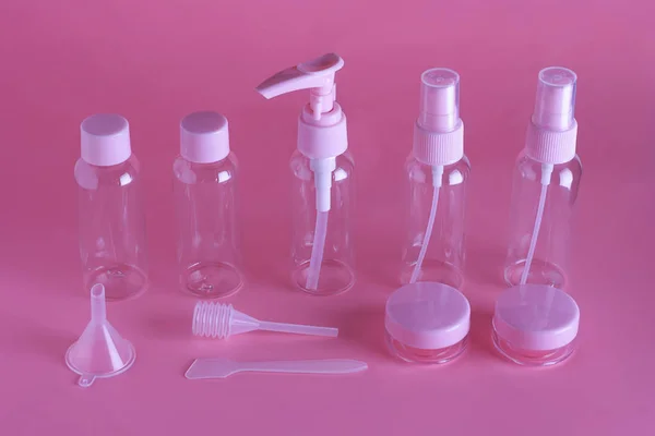 Cosmetic travel set. Various cosmetic bottles on a gently pink background with a copy space. A collection of cosmetic packaging for cream, soap, foam, shampoo. — Stock Photo, Image