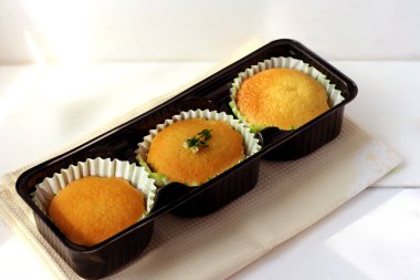 Ahşap bir masa üzerinde siyah çerez kesici taze pişmiş ev yapımı kekler. Üst te. Silikon şeklinde üç altın cupcakes